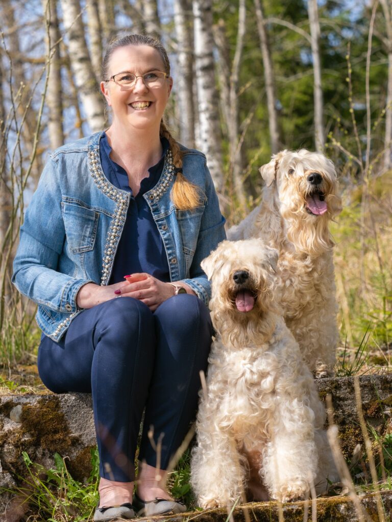 Nainen istuu kahden koiran kanssa 