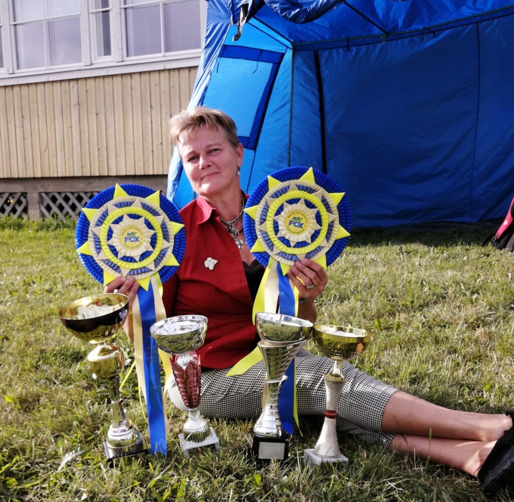 Nainen palkintojen kanssa kesällä